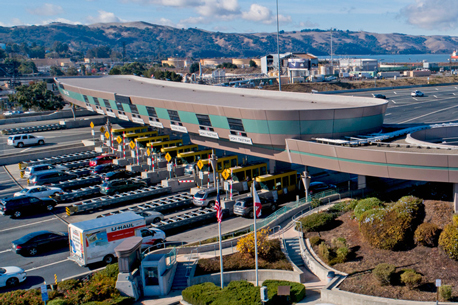 Ariel view of the Benicia-Martinez Bridge toll plaza with many cars waiting to go through.